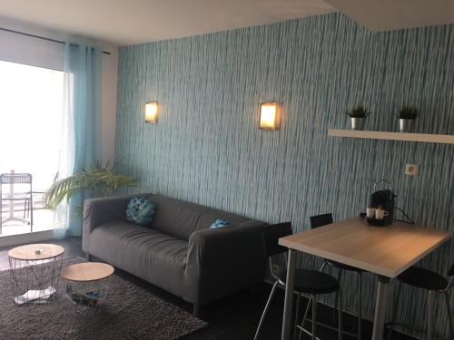 a living room with a couch and a table at Escapade au bord du lac du Bourget in Le Bourget-du-Lac