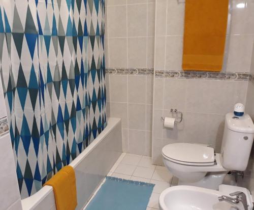 y baño con aseo, bañera y lavamanos. en Ana Mónica Pereira, en Vila Nova de Milfontes