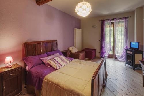 a bedroom with a large bed with purple sheets at Bed and Breakfast Ca D'Pandin in Peveragno