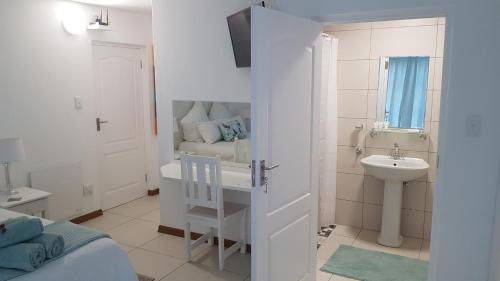 a white bathroom with a sink and a toilet at Berg en Dal Accommodation in Saldanha