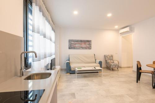 sala de estar con lavamanos y sofá en Apartamentos Guerrero 3 en Torre del Mar