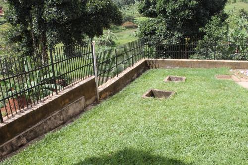 a garden with a fence and some grass at Namulanda Motel in Entebbe