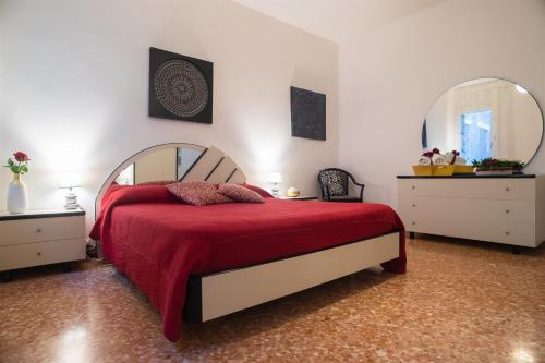 a bedroom with a bed with a red blanket and a mirror at CasaMisa Ca' Amaranta in Venice