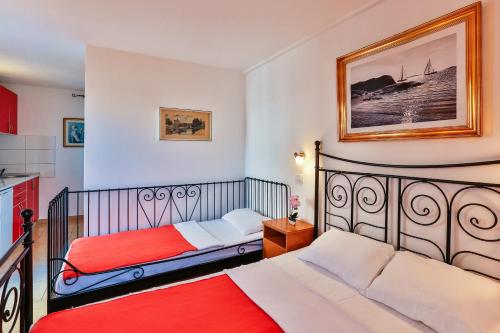 a bedroom with two beds and a kitchen at Apartmani Luka - Vila Brzulovic in Rafailovici