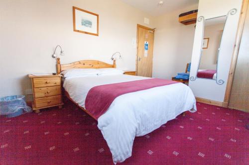 ein Schlafzimmer mit einem großen Bett und einem großen Spiegel in der Unterkunft Seaview John O Groats Hotel in John O Groats