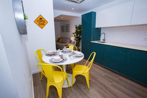 a kitchen with a table and yellow chairs in a room at Casas Madre de Deus in Évora