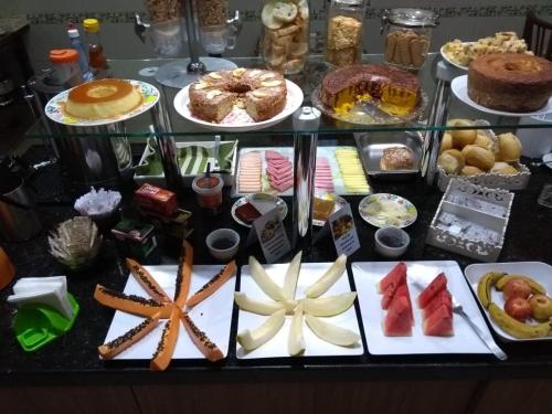 una mesa llena de diferentes tipos de comida en platos en POUSADA DOS AMIGOS en Presidente Venceslau
