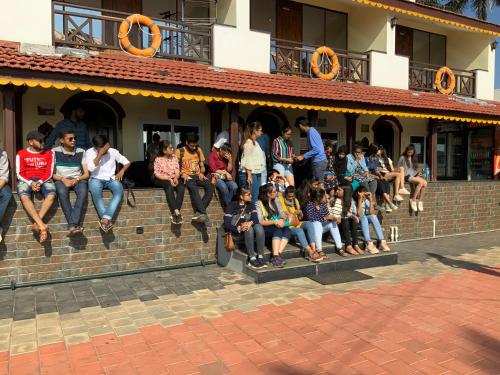a group of people sitting on the ledge of a building at Mermaid Island Beach Resorts in Puducherry