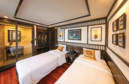 two beds in a room with a bedroom at Sena Cruises - Wonder On Lan Ha Bay in Ha Long