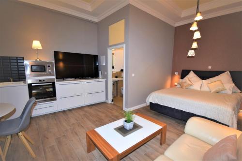 um quarto de hotel com uma cama e uma sala de estar em Connie's Apartments em Heidelberg