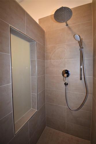 a shower with a shower head in a bathroom at Connie's Apartments in Heidelberg
