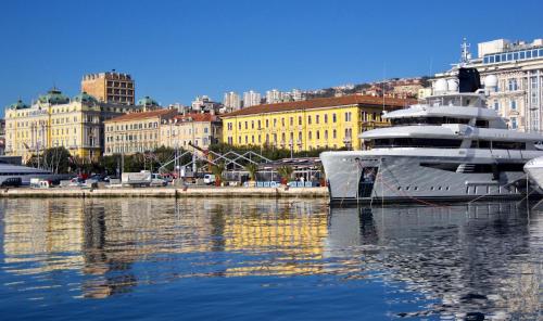 a large yacht docked in the water in a city at Sea star apartments in Rijeka