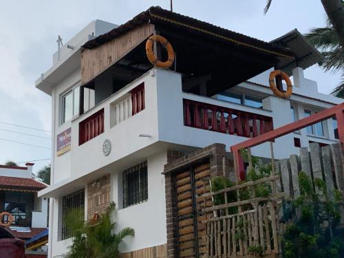 a white house with a balcony on top of it at Mermaid Island Beach Resorts in Puducherry