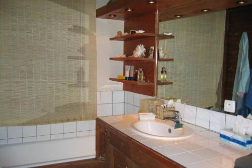 uma casa de banho com um lavatório, uma banheira e um espelho. em Chalet au coeur de la plagne em Plagne 1800