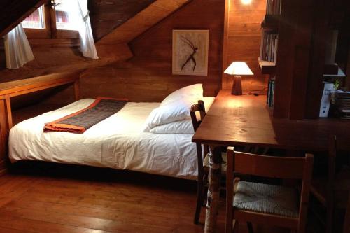 um quarto com uma cama, uma secretária e uma mesa em Chalet au coeur de la plagne em Plagne 1800