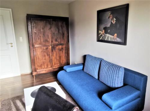 a living room with a blue couch and a piano at Aurach - SmartApart in Falkendorf