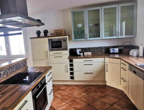a kitchen with white cabinets and a stove top oven at Aurach - SmartApart in Falkendorf