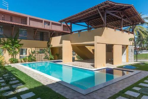 a house with a swimming pool in front of it at Reserva dos Corais in Cabo de Santo Agostinho