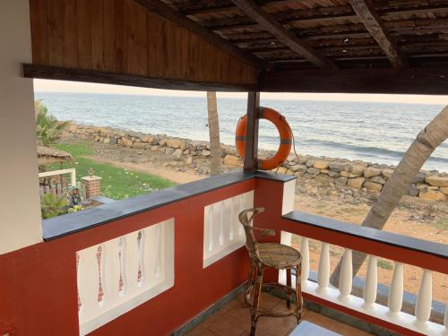 a balcony with a chair and a view of the ocean at Mermaid Island Beach Resorts in Puducherry