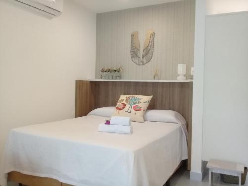 1 dormitorio con cama blanca y almohada en Apto. Orchidea no Ubaia Residence 202, en Pipa