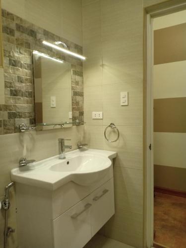 a bathroom with a white sink and a mirror at Villa Skanderbeg Guest House in Puerto Princesa City