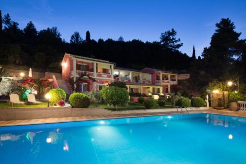 a villa with a swimming pool at night at Niki Sunrise Apartments in Gastourion