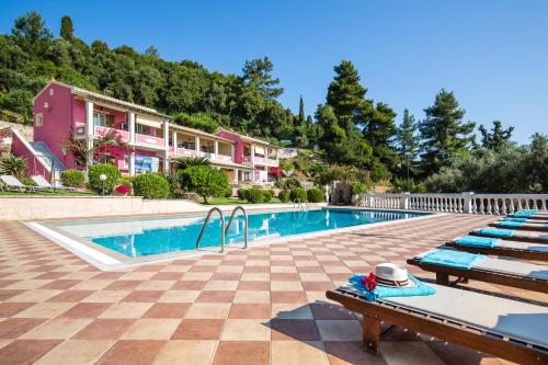 a swimming pool with lounge chairs and a resort at Niki Sunrise Apartments in Gastourion