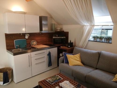 a living room with a couch and a kitchen at BC bed en comfort in Bilzen