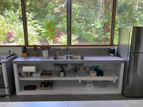 a kitchen with a sink and a refrigerator at Scarlet House in Carate