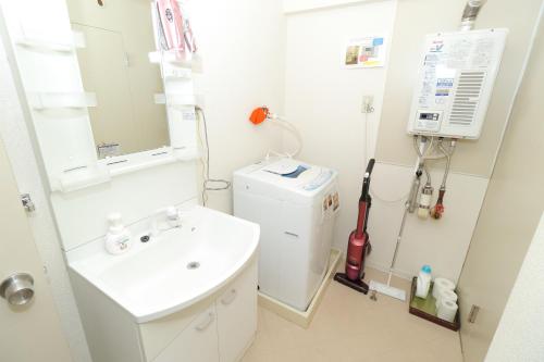 a bathroom with a sink and a washing machine at 札幌市中心部大通公園まで徒歩十分観光移動に便利なロケーションh202 in Sapporo