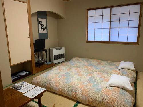 a bedroom with a bed and a table and a window at Annex Turtle Hotori-An in Nikko