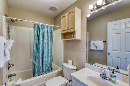 a bathroom with a toilet and a sink and a mirror at Navarre Beach Sunset Condo in Navarre