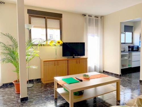 ein Wohnzimmer mit einem Tisch und einem TV in der Unterkunft Apartamento diáfano y luminoso en Onil in Onil
