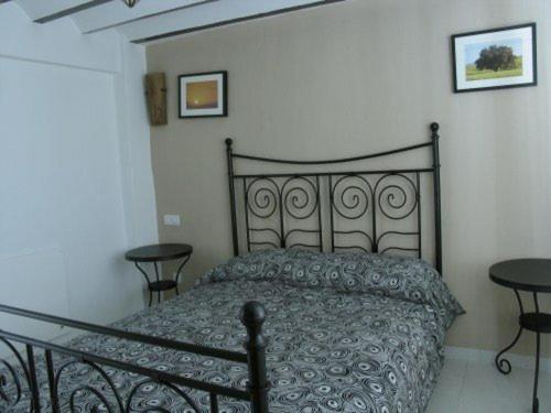een slaapkamer met een zwart bed en 2 tafels bij Casa El Minarete in Huéscar