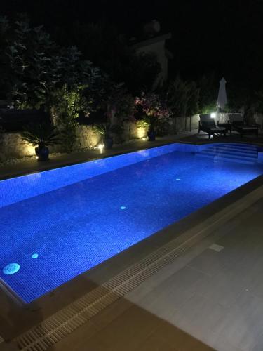 a swimming pool lit up at night at Casa Santos Kyrenia in Kérynia