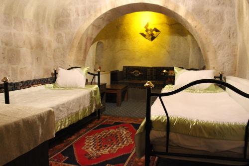 a room with two beds and a couch at Dilek Tepesi Cave Hotel in Ayvalı