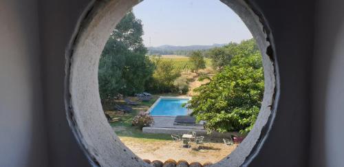 a view of a swimming pool through a window at Le Mas Neuf des Greses in Canaules-et-Argentières