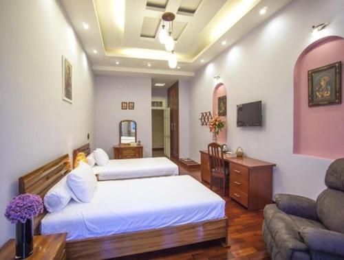 a hotel room with two beds and a couch at Dalat Terrasse Des Roses Villa in Da Lat