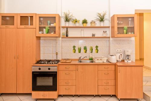 - une cuisine avec des placards en bois et une cuisinière dans l'établissement Danubius Grand Astoria Budapest, à Budapest