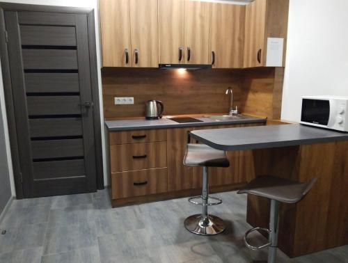 a small kitchen with a sink and a counter with stools at Апарт-сервис s1 in Uzhhorod