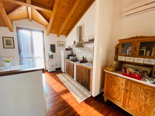 eine große Küche mit Holzböden und einem großen Fenster in der Unterkunft Il nido della cicogna in Certosa di Pavia