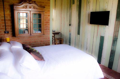 a bedroom with a white bed and a window at El Granero in Sierra de los Padres