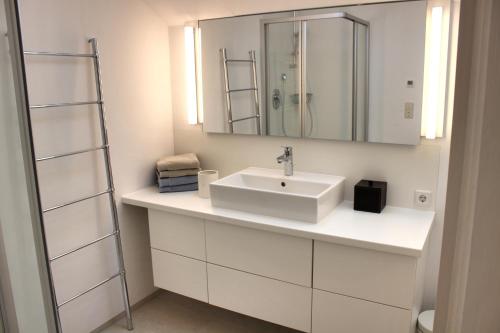 a white bathroom with a sink and a mirror at Ferienhaus Alpennest in Radstadt