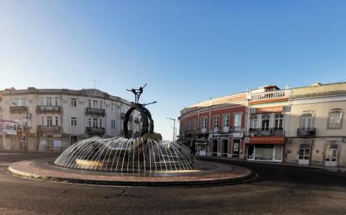 a fountain in the middle of a city with buildings at Downtown Loulé in Loulé