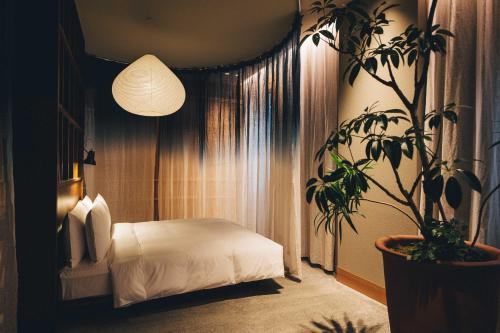 a bedroom with a bed and a potted plant at Hotel K5 in Tokyo