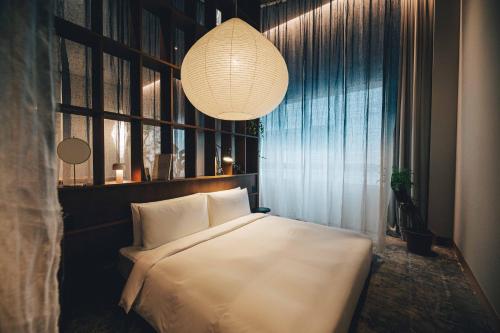 a bedroom with a white bed and a chandelier at Hotel K5 in Tokyo