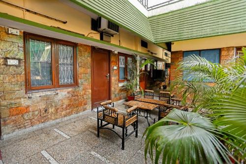 a patio with tables and chairs on a building at The Trekkers Hostel - Dehradun in Dehradun