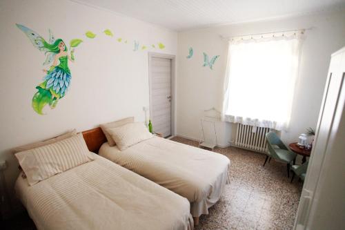 1 dormitorio con 2 camas y un mural de sirena en la pared en Casa Cristallo en Gesso