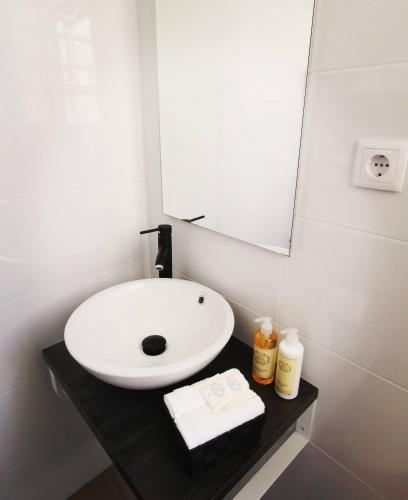 a bathroom with a white sink and a mirror at Downtown Loulé in Loulé