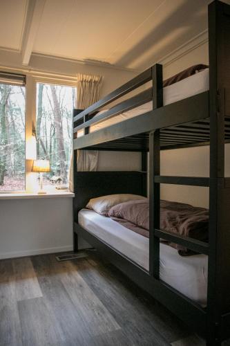 a bedroom with two bunk beds and a window at Vakantiehuis 't Musje in Epe
